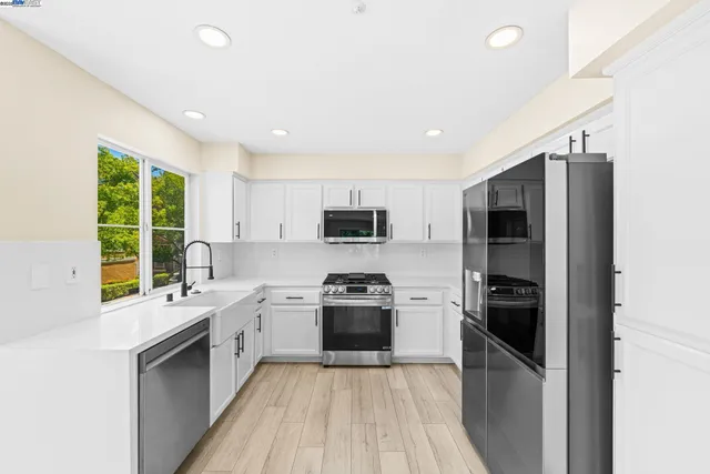 a kitchen with a sink stainless steel appliances and cabinets