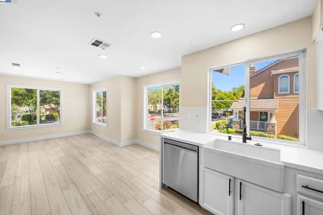 a kitchen with stainless steel appliances a sink and wooden floor