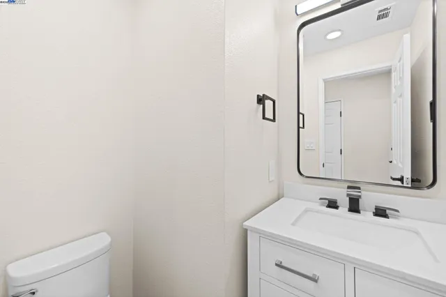 a bathroom with a sink a toilet and mirror