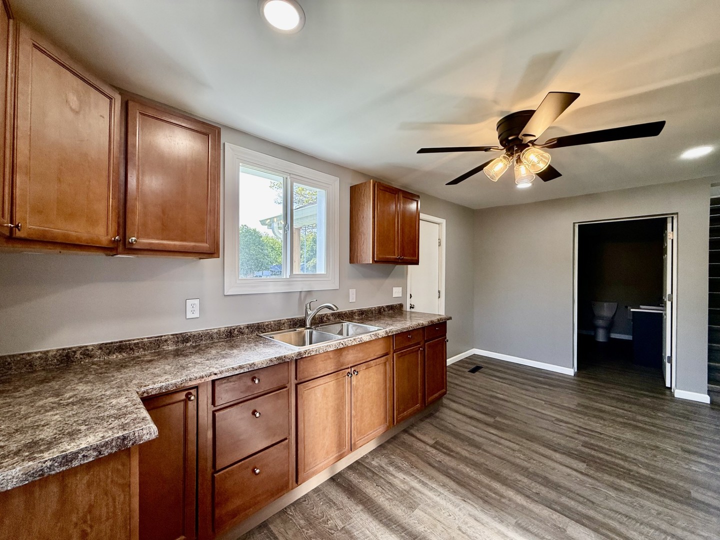 2703 Main Street Peru, IL 61354 - Photo 12 of 23 a kitchen with stainless steel appliances granite countertop wooden cabinets a sink a stove a dining table and chairs with wooden floor