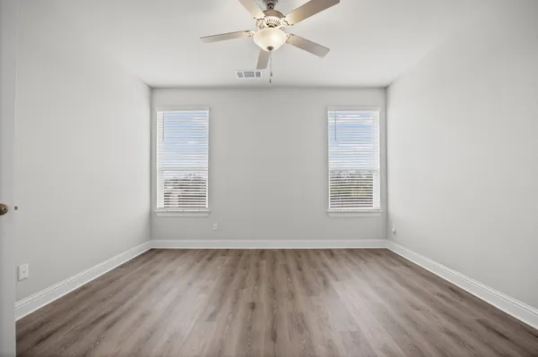 an empty room with a window and a ceiling fan