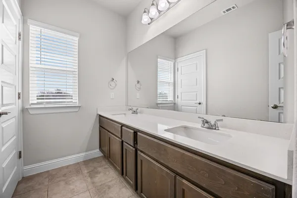a bathroom with a sink double vanity and a window