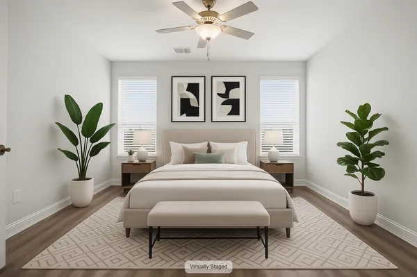 a bedroom with a large bed and a potted plant