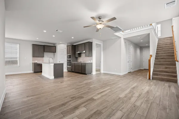 a view of a electric appliances in kitchen and empty room with wooden floor