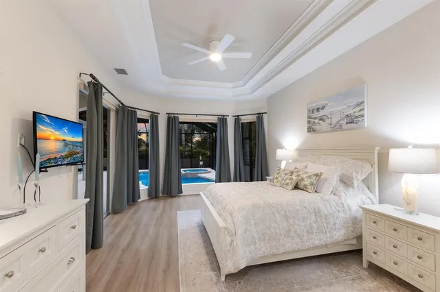 a bedroom with a large bed and a flat tv screen on dresser