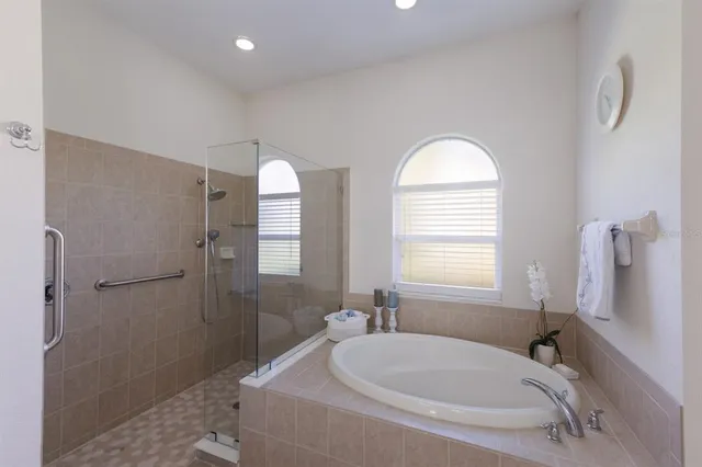 a bathroom with a tub sink and mirror