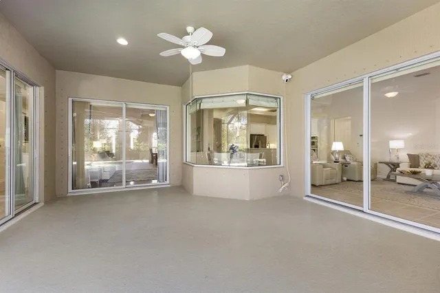 a view of a backyard with table and chairs and potted plants and large trees