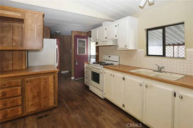 a kitchen with stainless steel appliances granite countertop a sink a stove and a refrigerator