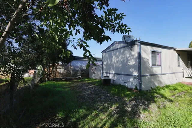 a view of a yard in front of a house with a large tree