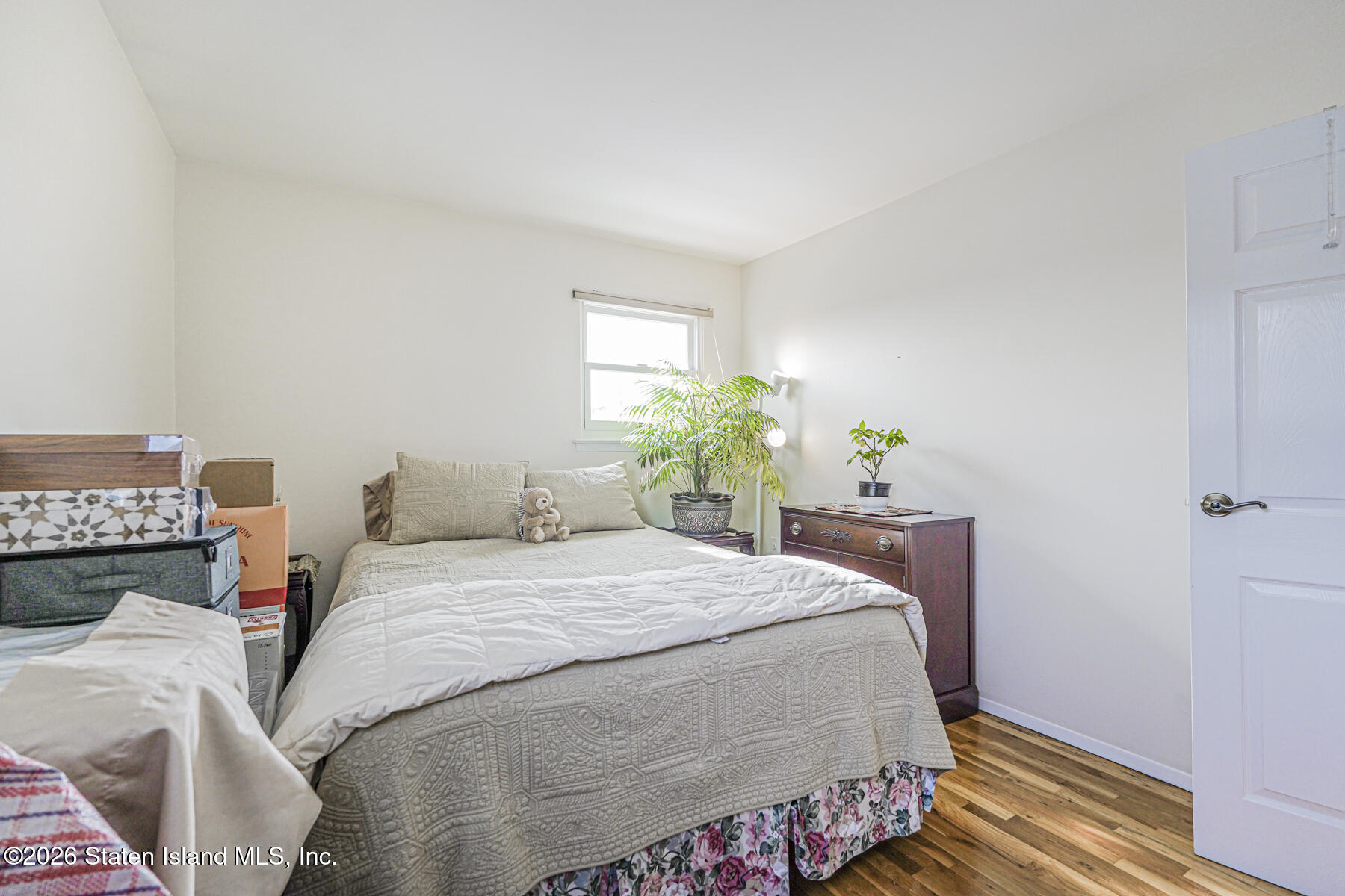 76 Berry Avenue Staten Island, NY 10312 - Photo 28 of 42 a bedroom with a bed a closet and a potted plant