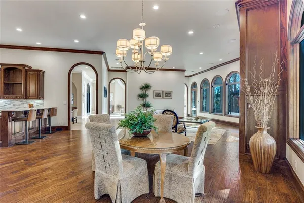 a view of a dining room with furniture a chandelier and wooden floor