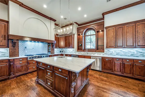 a kitchen with stainless steel appliances granite countertop a stove a sink and a microwave
