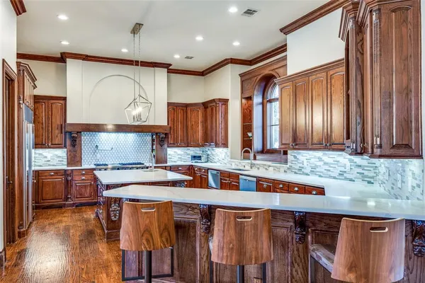 a kitchen with stainless steel appliances granite countertop a stove a sink and a refrigerator