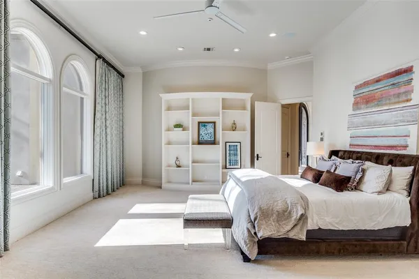 a bedroom with a large bed and a chandelier