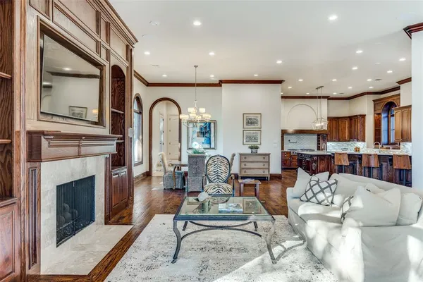 a living room with furniture a fireplace and a kitchen view