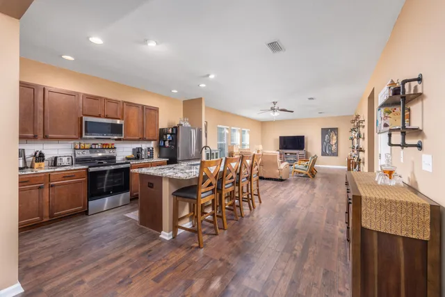 a kitchen with lots of wooden furniture appliances and wooden cabinets