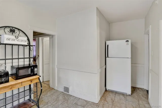 a white refrigerator freezer and a stove sitting inside of a kitchen