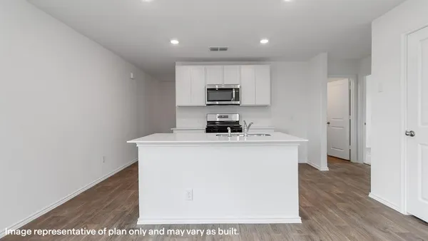 a kitchen with a sink a stove and cabinets