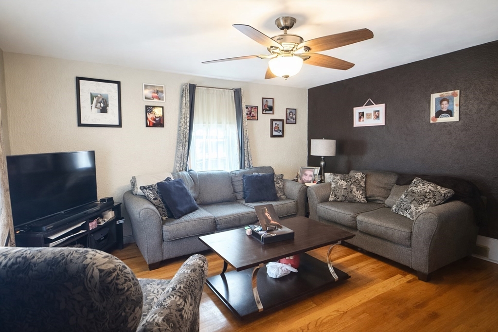 83 Gilman Street Springfield, MA 01118 - Photo 3 of 11 a living room with furniture a ceiling fan and a flat screen tv