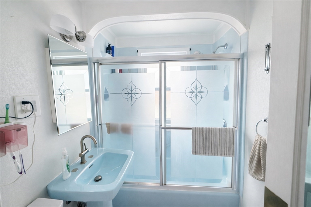 83 Gilman Street Springfield, MA 01118 - Photo 9 of 11 a bathroom with a sink a glass door shower and a mirror