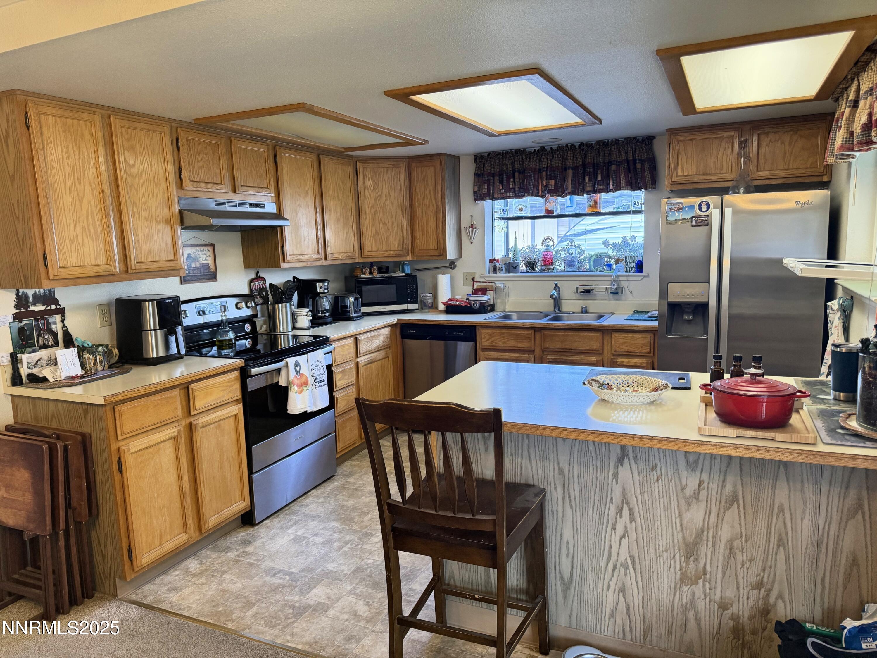 1348 Leonard Road Gardnerville, NV 89460 - Photo 6 of 13 a kitchen with stainless steel appliances granite countertop a stove refrigerator and a sink