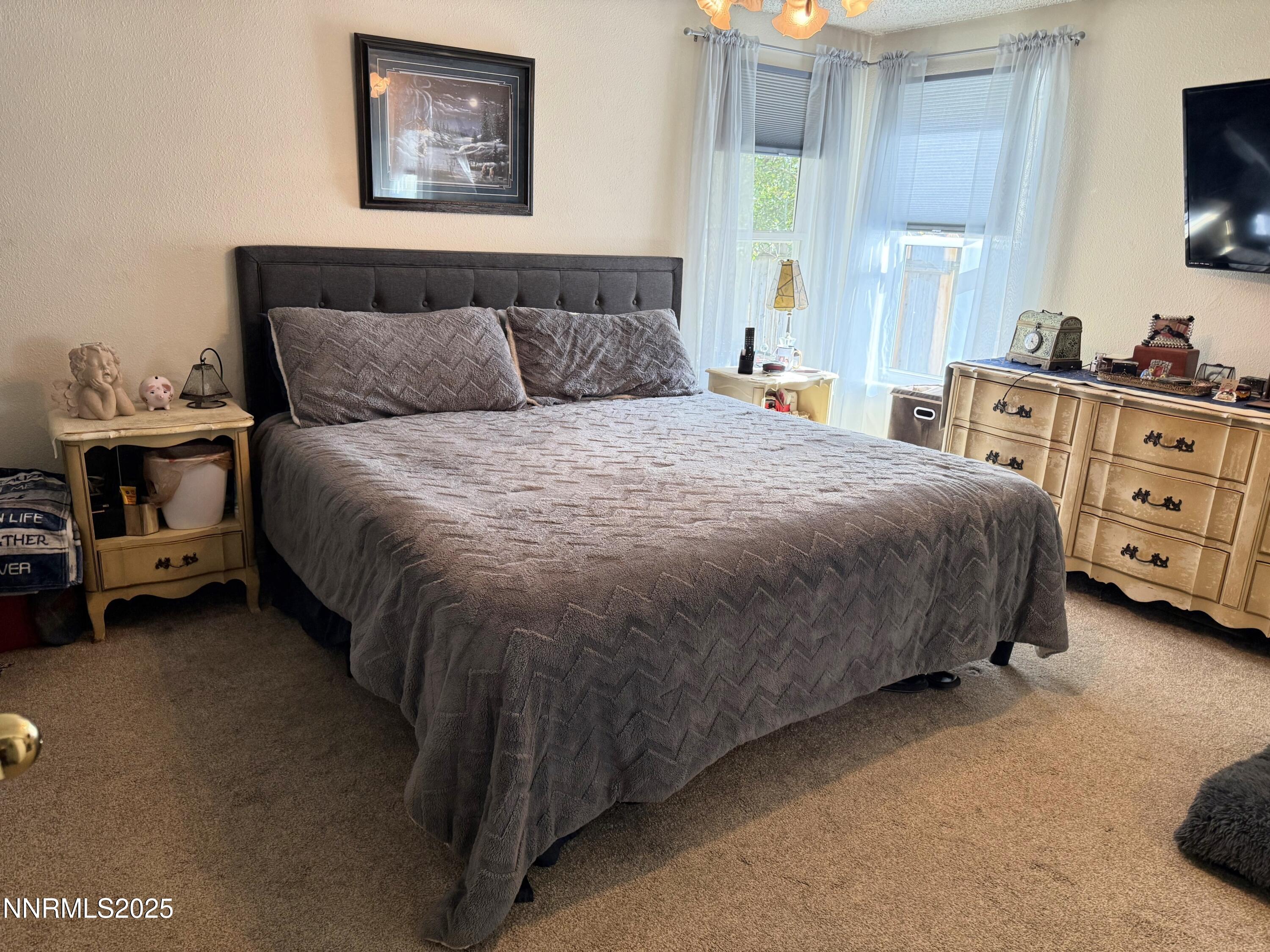 1348 Leonard Road Gardnerville, NV 89460 - Photo 8 of 13 a spacious bedroom with a bed and a flat tv screen on a dresser