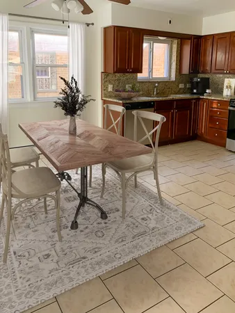 a kitchen with a table chairs sink and cabinets