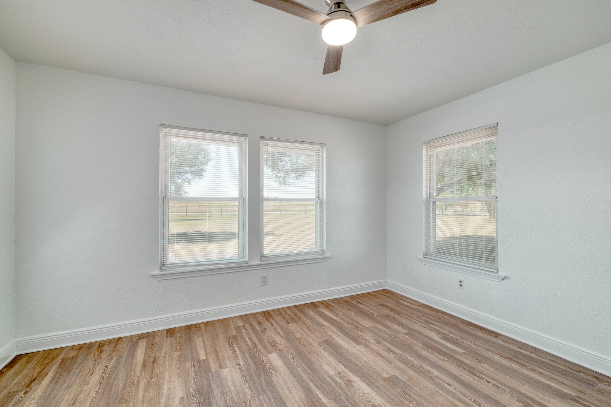 20960 Cameron Road Coupland, TX 78615 - Photo 10 of 21 Warm wood-look flooring and multiple windows create a comfortable interior atmosphere.