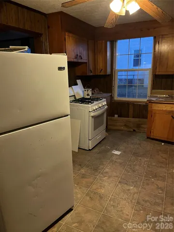 a kitchen with a refrigerator and a stove top oven