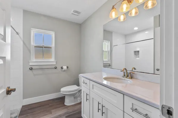 a bathroom with a toilet a sink and mirror