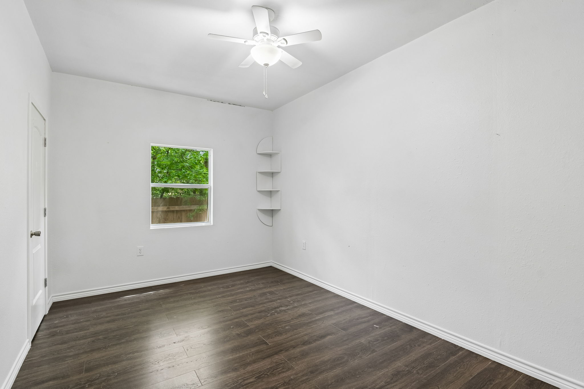 810 Lamar Street Luling, TX 78648 - Photo 17 of 21 an empty room with wooden floor and windows