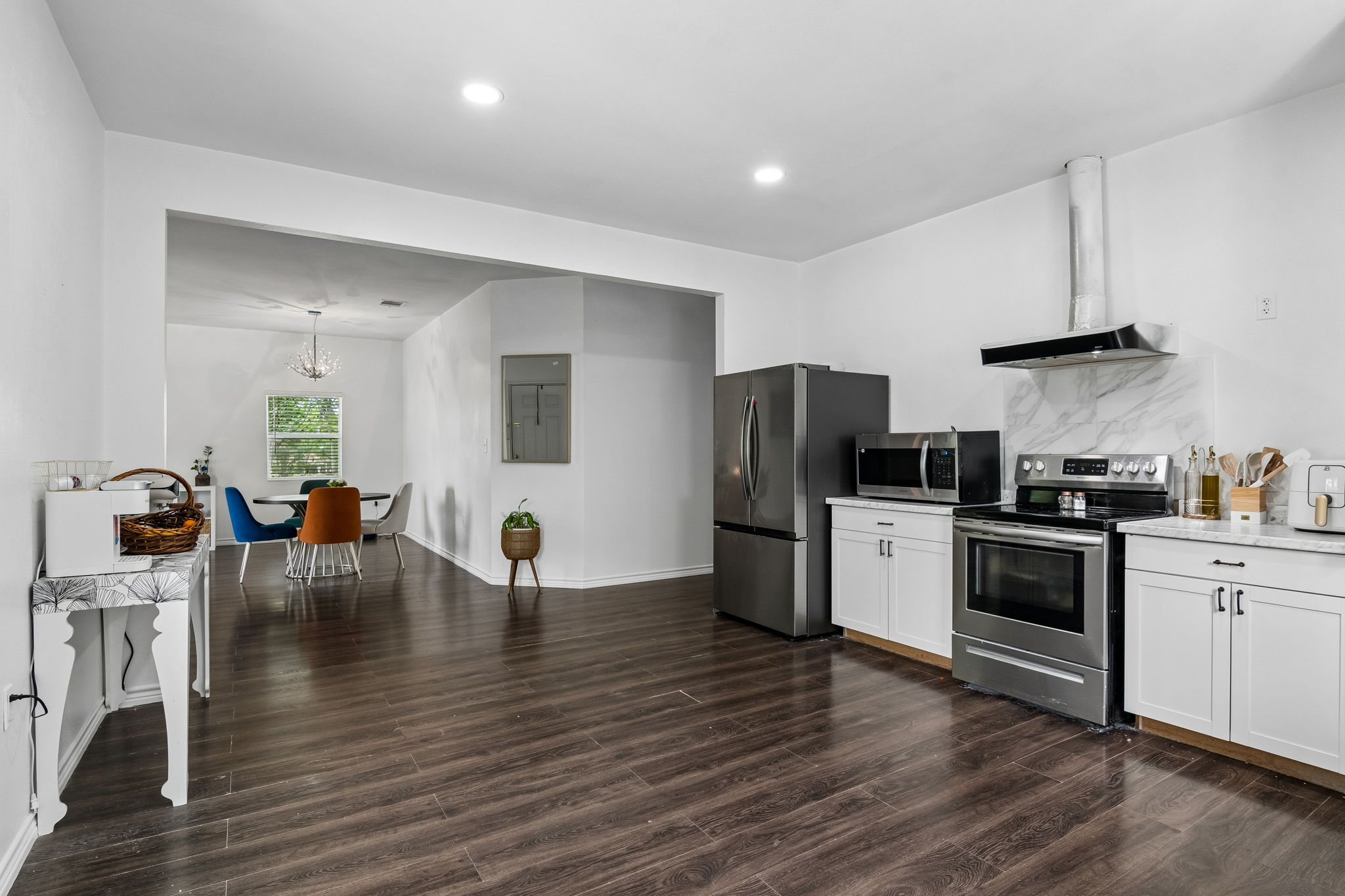 810 Lamar Street Luling, TX 78648 - Photo 6 of 21 a kitchen with stainless steel appliances a stove a sink a refrigerator white cabinets and wooden floor