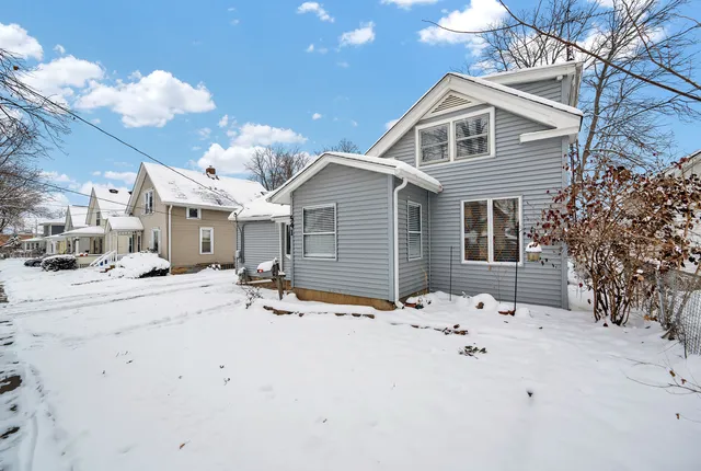 a front view of a house with a yard covered in snow
