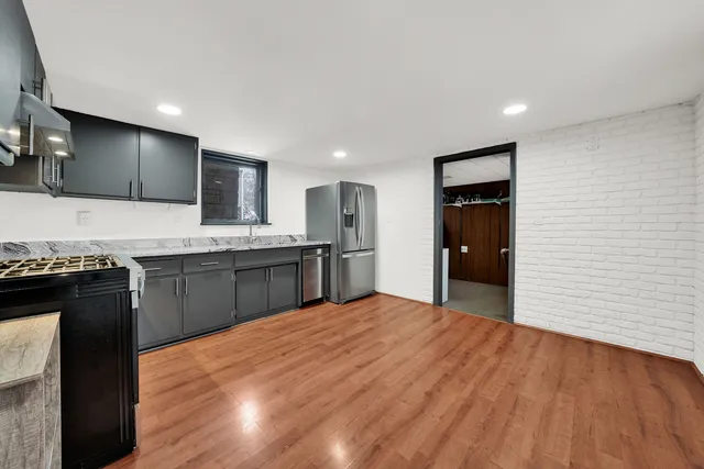 a kitchen with stainless steel appliances granite countertop a stove a sink and a refrigerator