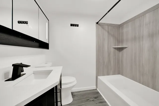 a bathroom with a sink a toilet and shower