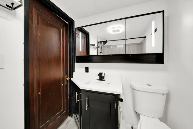 a bathroom with a sink a toilet and mirror