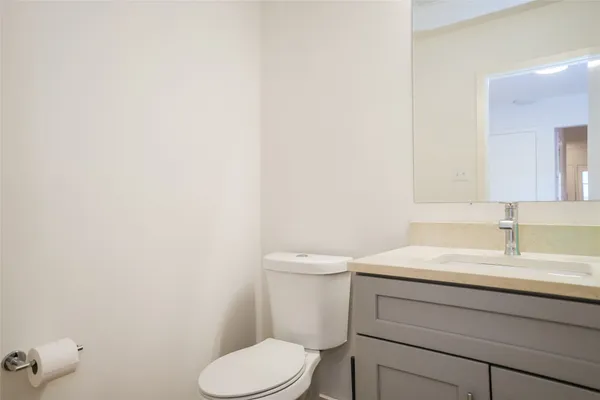 a bathroom with a toilet sink vanity and mirror