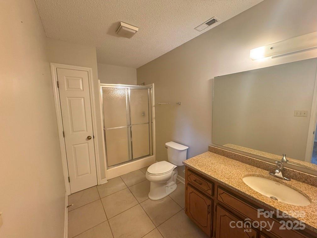 578 Wren Road Gastonia, NC 28056 - Photo 11 of 12 a bathroom with a granite countertop sink a toilet a mirror and a shower