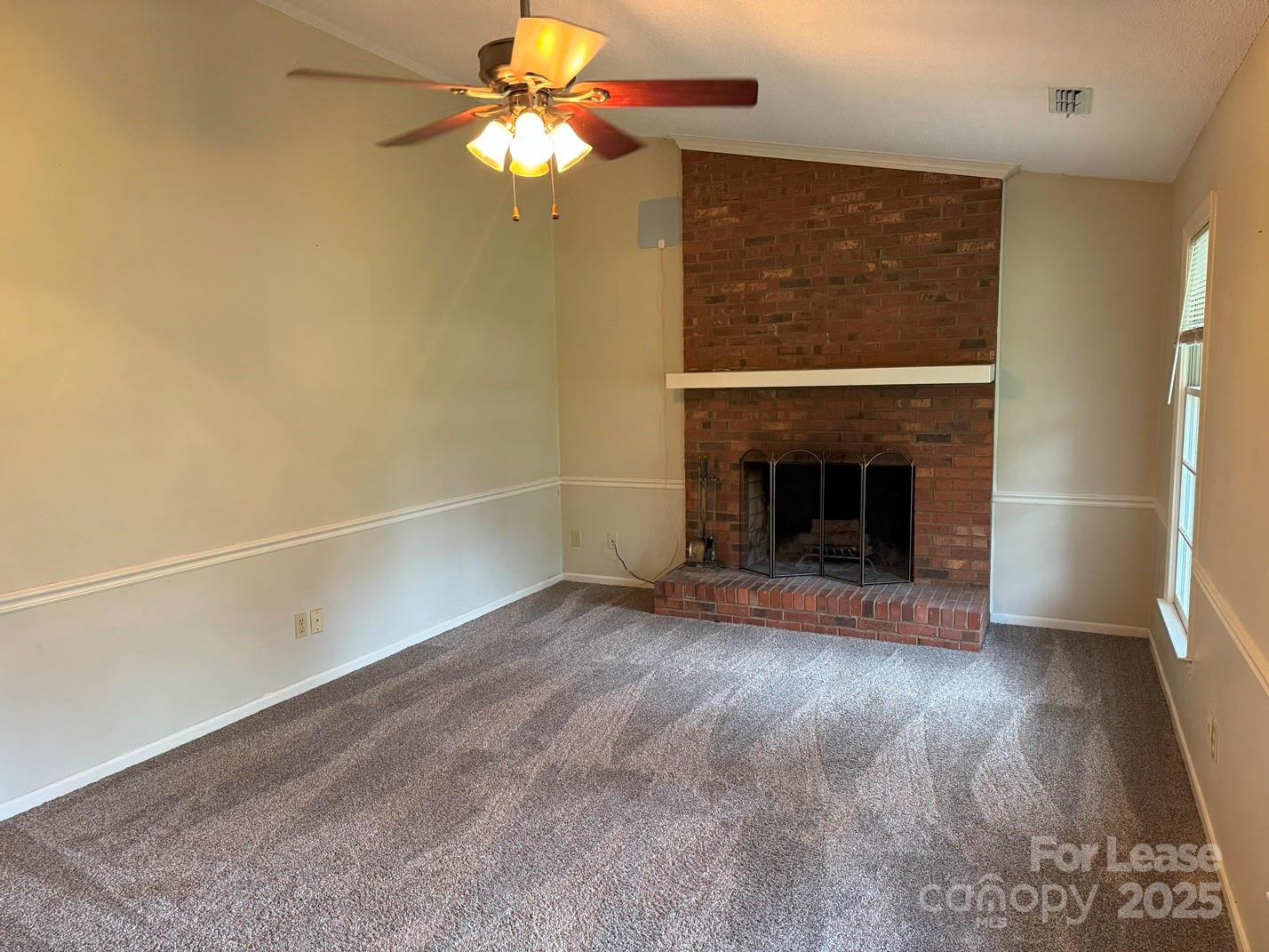 578 Wren Road Gastonia, NC 28056 - Photo 3 of 12 an empty room with windows fireplace and fan