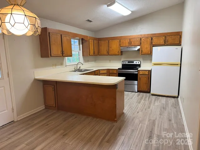 a kitchen with stainless steel appliances granite countertop a sink stove and refrigerator