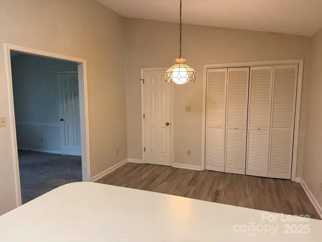 a view of a room with wooden floor and wooden door