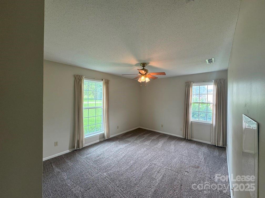 578 Wren Road Gastonia, NC 28056 - Photo 7 of 12 an empty room with windows and chandelier fan