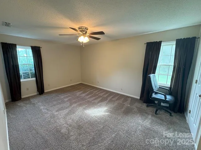 a view of a livingroom with a ceiling fan and window