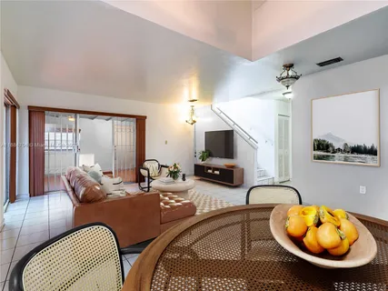 a living room with furniture a flat screen tv and a large window