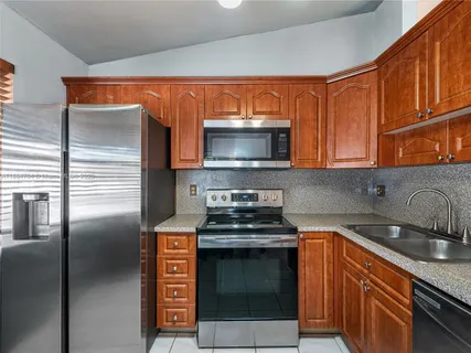 a kitchen with stainless steel appliances granite countertop a stove microwave and sink