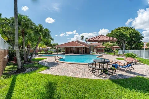 a view of a chair and table in backyard of the house