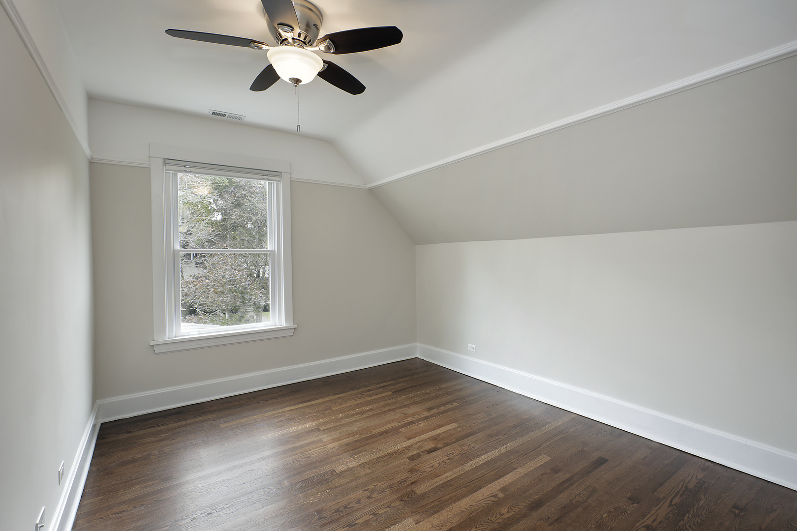 1121 Grant Street, Unit 2 Evanston, IL 60201 - Photo 6 of 8 an empty room with wooden floor ceiling fan and windows