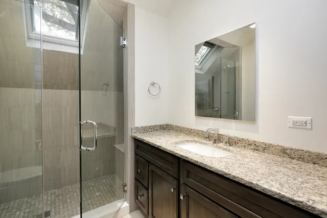 a bathroom with a granite countertop sink and mirror