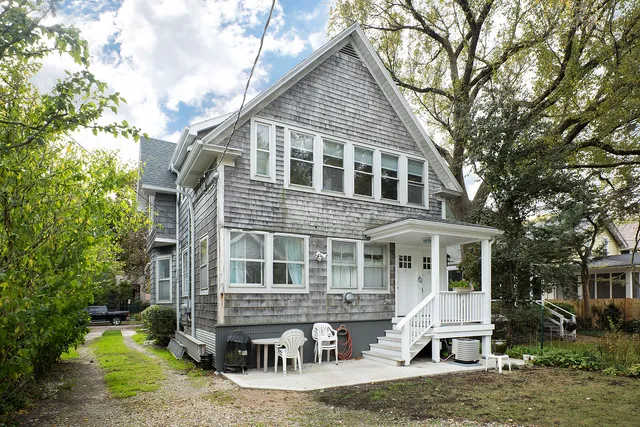 a front view of a house with yard porch and sitting area