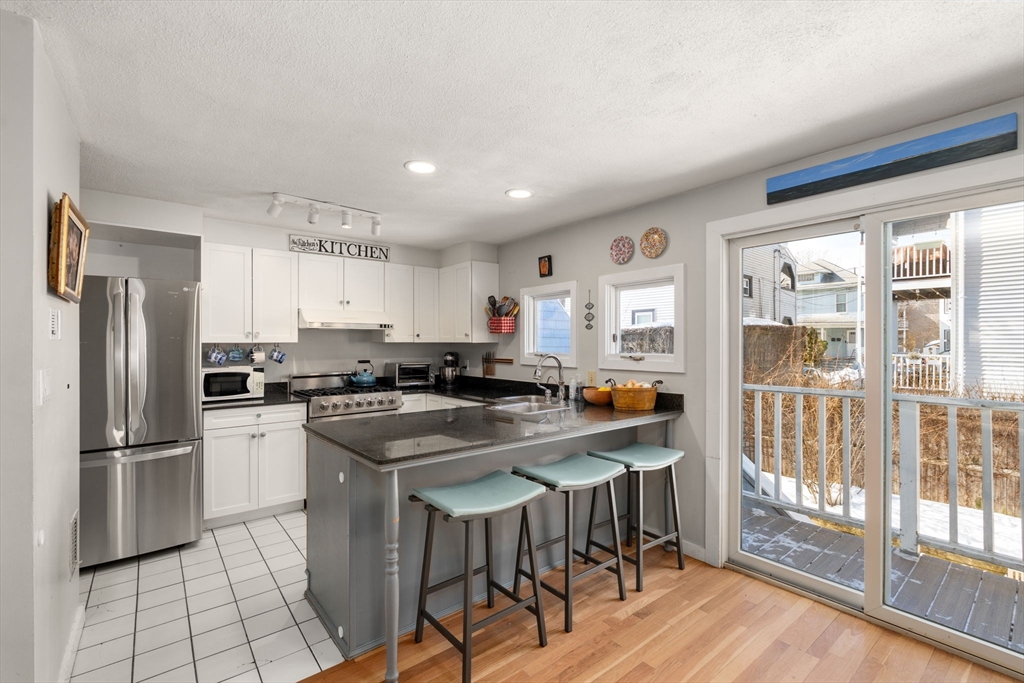 a kitchen with stainless steel appliances granite countertop a refrigerator and a stove top oven